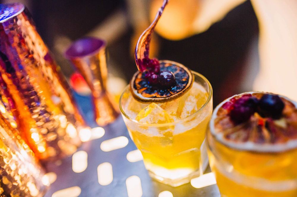 Primer plano de un cocktail terminándose de decorar con una guinda