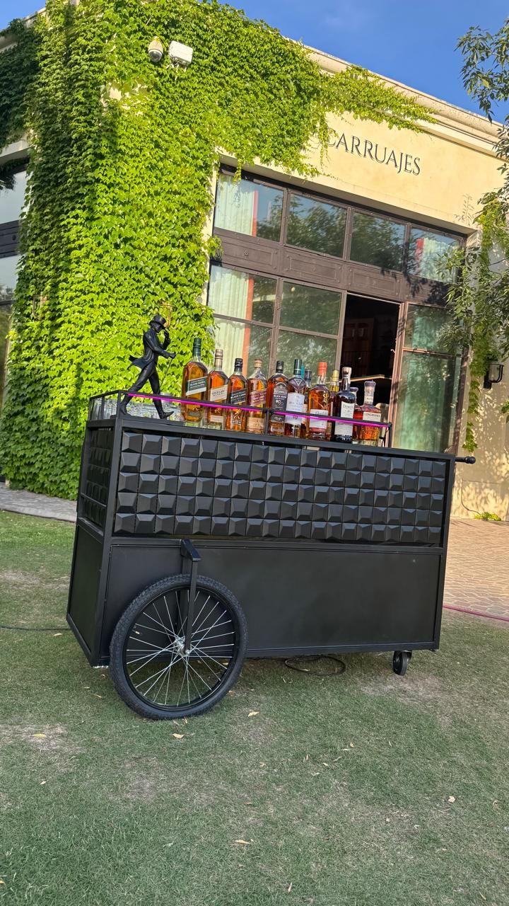 Carrito de whisky Holy Champagne con botellas de etiquetas premium al aire libre